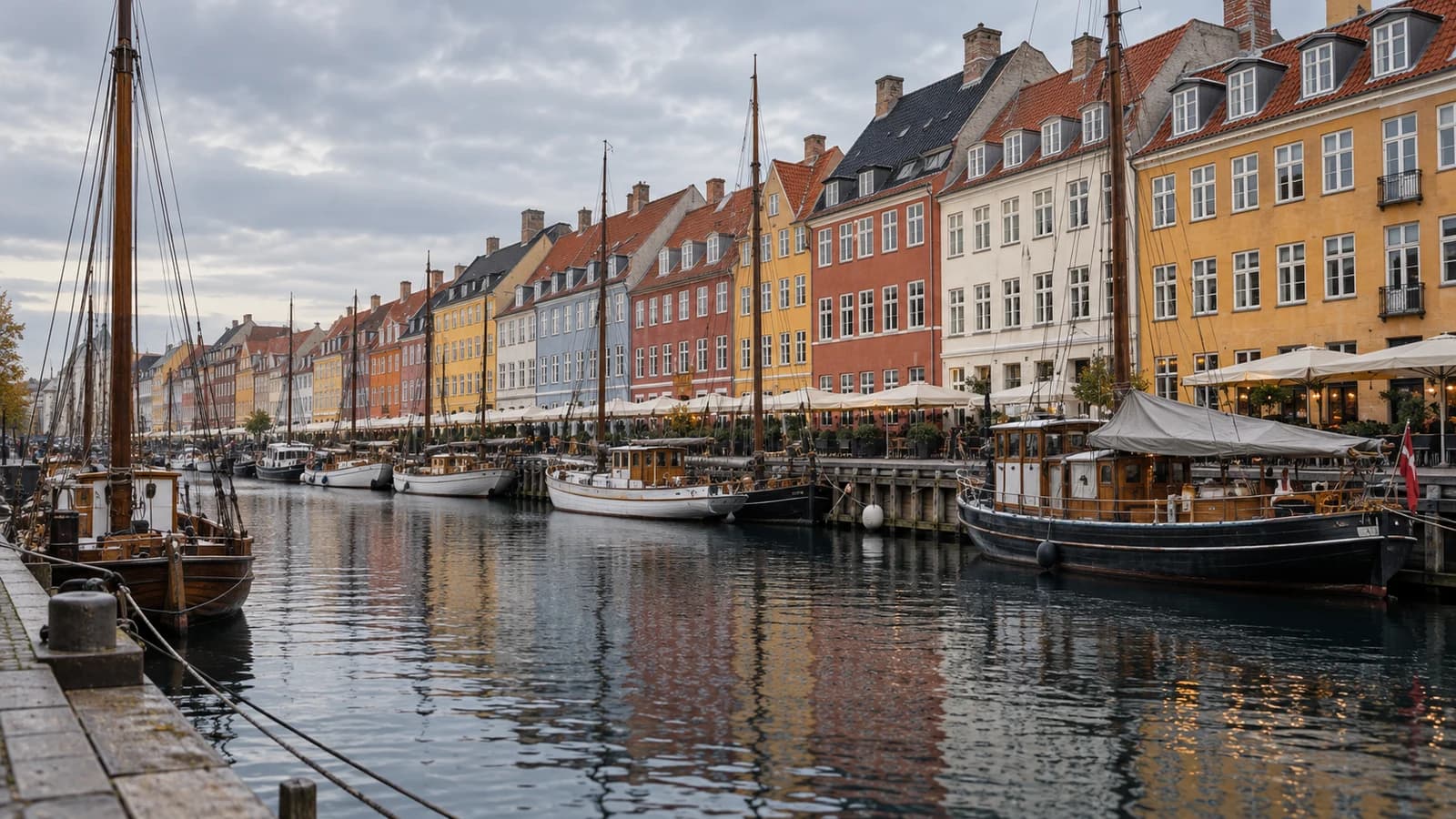 AI-created editorial view of colourful historic buildings and moored boats along Nyhavn canal in Copenhagen under natural autumn daylight.