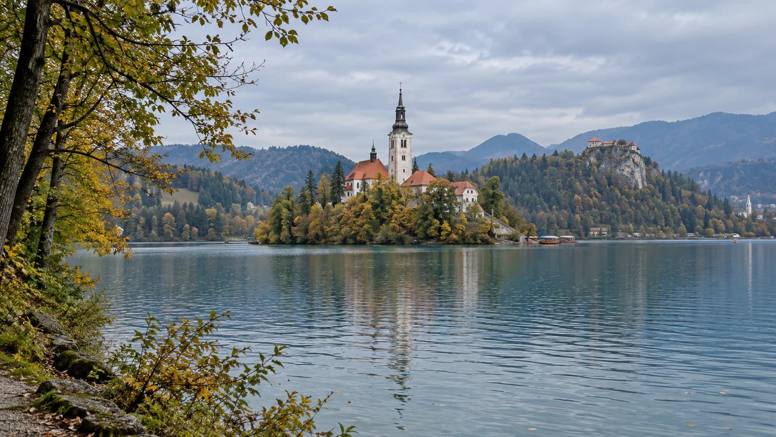 KI-generiertes redaktionelles Motiv des Bleder Sees mit Inselkirche und Burg bei natĂĽrlichem herbstlichem Tageslicht.